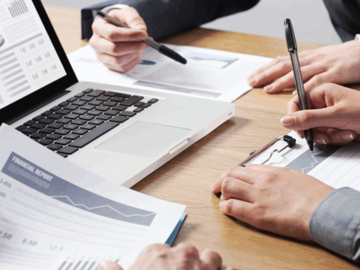A closeup of hands, screens, and papers as workforce development leaders plan.