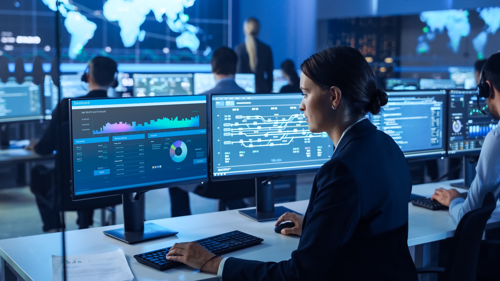 Team of Professional Computer Data Science Engineers Work on Desktops with Screens Showing Charts, Graphs, Infographics, Technical Business Data and Statistics. Dark Control and Monitoring Room.