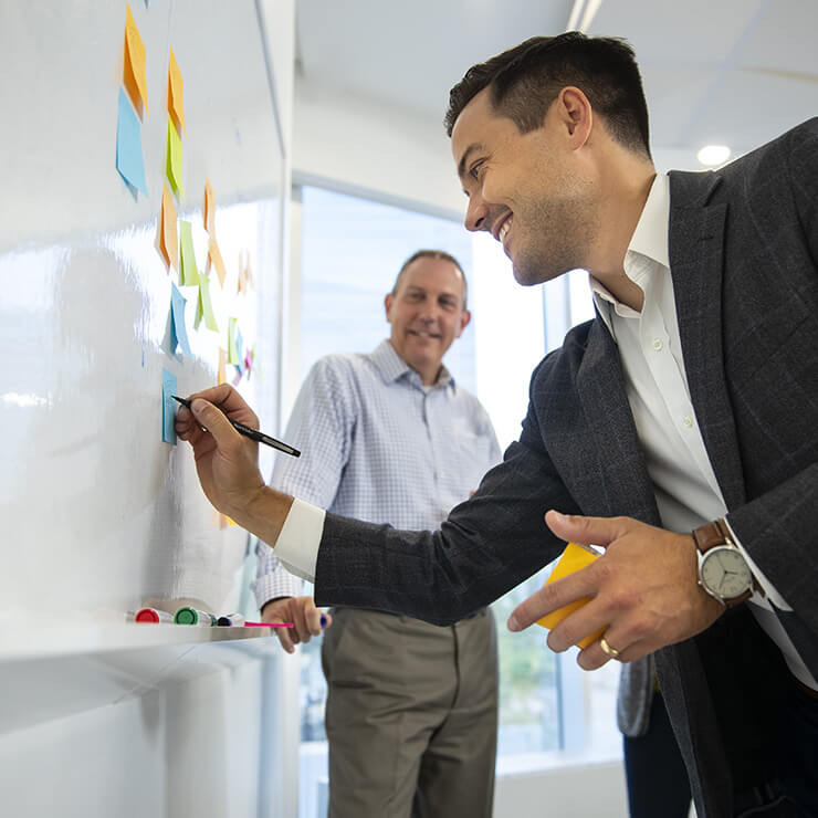 Two Men Collaborating with Post-its